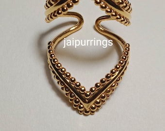 May include: A gold-toned ring featuring two V-shaped components connected by a central band. Each V-shaped section is lined with small, raised spherical beads along the outer edges. The text "jaipurrings" is printed in the center of the ring.