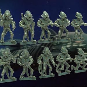 May include: A set of ten green plastic toy figures of aliens with large heads and guns. The figures are posed in various action stances.