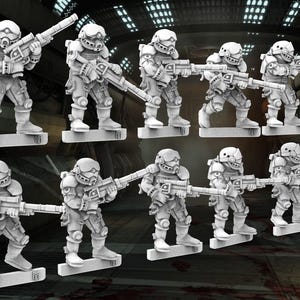 May include: A collection of nine miniature figurines of futuristic soldiers in combat gear, each holding a rifle. The figures are light gray and stand on rectangular bases. The background is a dark, industrial setting.