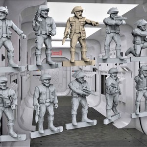 May include: A set of ten gray and beige plastic miniature figures of soldiers wearing helmets and holding weapons. The figures are displayed on a white background.
