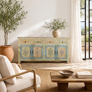 Könnte beinhalten: Eine weiße Keramik-Tasse mit schwarzem Henkel und dem Text "But First, Coffee" in fetter, schwarzer Schrift. Die Tasse steht vor einem verschwommenen Hintergrund, der eine gemütliche Umgebung suggeriert.