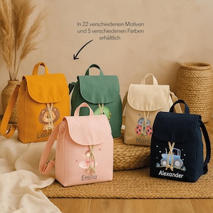 Può includere: Sono esposti cinque zaini colorati con chiusure a patta e parte superiore con coulisse. Ogni zaino presenta un design diverso, tra cui un leone, una fata, una coccinella, un trattore e un dinosauro. I nomi Leon, Emilia, Maria e Alexander sono stampati sulle borse.