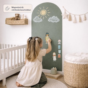 May include: An arched, sage green magnetic chalkboard wall decal featuring a sun and cloud drawing in white chalk. The board includes magnetic paper doll figures and various clothing accessories that can be attached to the surface for interactive play.