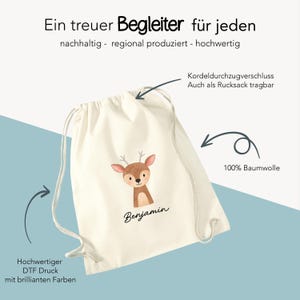 Puede incluir: Mochila con cord&oacute;n de color crema con una ilustraci&oacute;n de ciervo y el nombre "Benjamin". La bolsa tiene un cierre de cord&oacute;n y est&aacute; hecha de 100% algod&oacute;n. El texto en la bolsa dice "Un compa&ntilde;ero leal para todos".