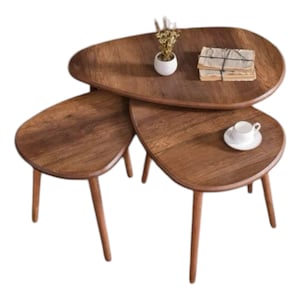 Puede incluir: Un conjunto de tres mesas nido de madera oscura, cada una con una forma ovalada única. Las mesas están apiladas, con la más grande en la parte inferior y la más pequeña en la parte superior. Tienen un diseño simple y moderno y serían una gran adición a cualquier sala de estar u oficina.