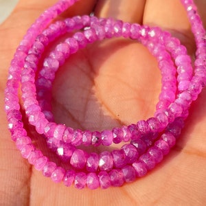 May include: A strand of pink ruby beads, faceted and strung on a thin wire. The beads are small and uniform in size, creating a delicate and elegant look.