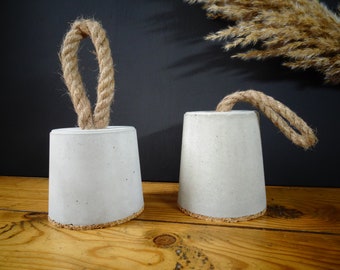 Small concrete door stopper with jute cord handle, useful and esthetic accessory for home