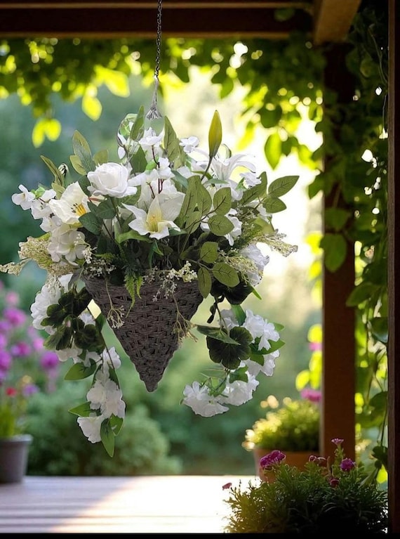 Handgefertigter Hängekorb mit künstlichen Blumen, der mit einem gemischten Blumenstrauß aus Weiß und Creme überfüllt ist