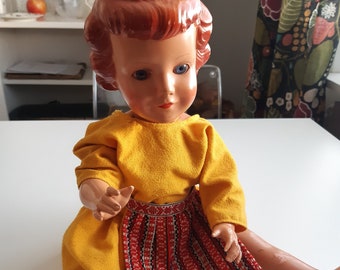 Vintage celluloid doll in a yellow dress