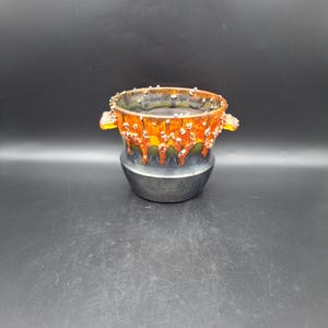 May include: A set of three ceramic mugs with a speckled, matte finish. The mugs are in shades of cream, light gray, and dark gray. Each mug has a simple, minimalist design, perfect for coffee or tea.