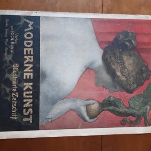 May include: A vintage magazine cover featuring a woman with a crown of flowers, holding a turnip. The cover is titled "Moderne Kunst" and is a German illustrated magazine.