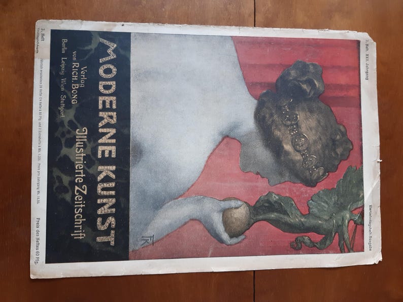 May include: A vintage magazine cover featuring a woman with a crown of flowers, holding a turnip. The cover is titled "Moderne Kunst" and is a German illustrated magazine.