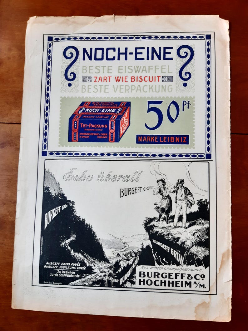 May include: A vintage advertisement for Burgeff & Co. Hochheim/M. wine. The ad features a black and white illustration of a couple standing on a cliff overlooking a valley. The text reads "Echo &uuml;berall Burgeff Gr&uuml;n" and "Aus echten Champagnerweinen. Burgeff & Co. Hochheim/M."