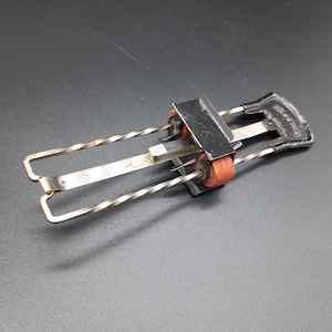 May include: A vintage metal tool with two rotating wheels and a spring-loaded mechanism. The tool has a black handle with the text "CONRAD & CO. NEW YORK" printed on it.