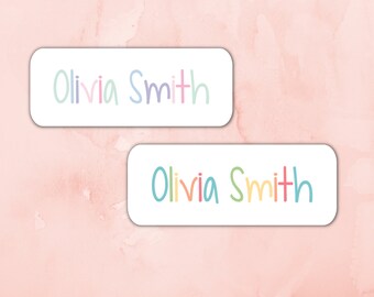 Puede incluir: Dos etiquetas rectangulares blancas con el nombre "Olivia Smith" escrito en letras coloridas manuscritas.