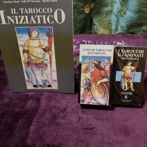 May include: A set of three tarot card decks, including "Il Tarocco Iniziatico", "Antichi Tarocchi Illuminati", and "I Tarocchi Illuminati Sola-Busca". The decks are all in Italian and feature colorful illustrations.