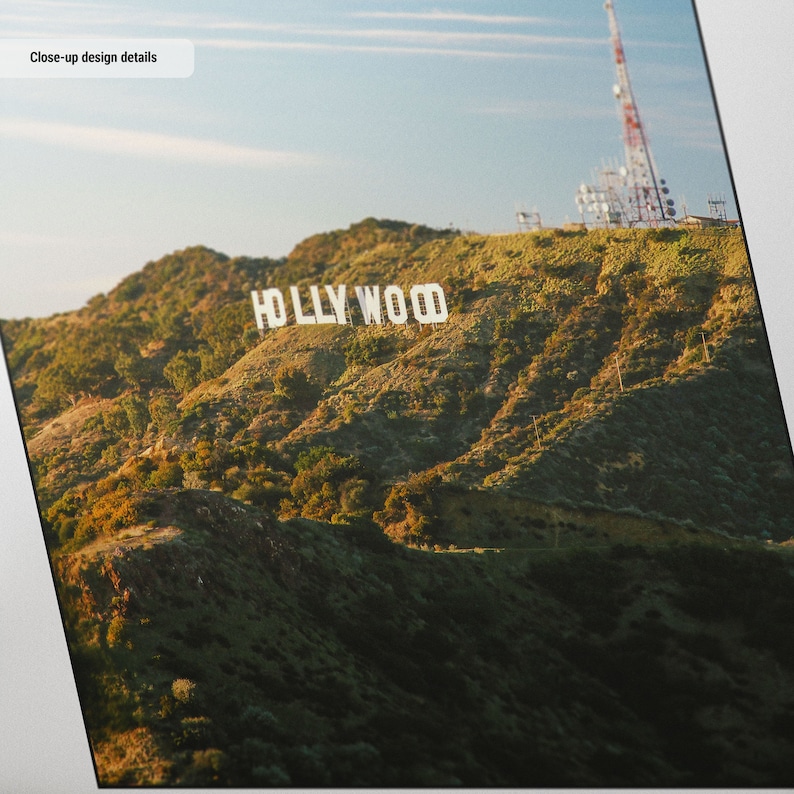 May include: A panoramic view of the iconic Hollywood sign, set against a backdrop of rolling hills and a clear blue sky. The sign is white and stands out against the green foliage.