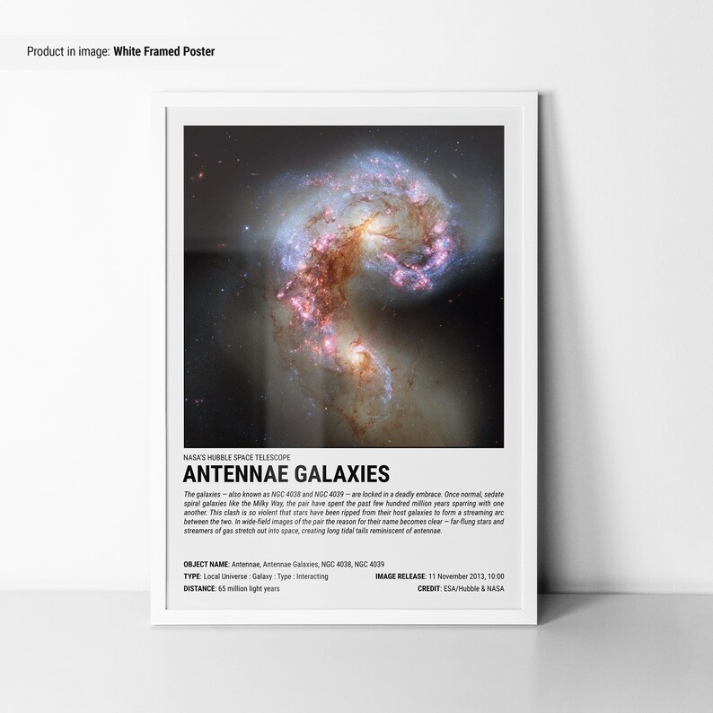May include: White framed poster featuring the Antennae Galaxies, captured by the Hubble Space Telescope. The image showcases two interacting galaxies with swirling arms of stars and gas, in shades of red, pink, and blue. Text at the bottom provides details about the galaxies.