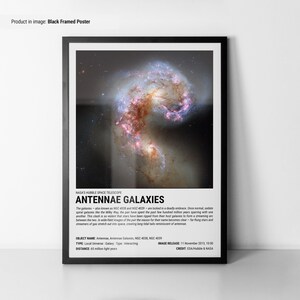 May include: Black framed poster featuring the Antennae Galaxies, a pair of interacting galaxies. The image showcases swirling formations of stars and gas, with vibrant pink and blue hues. Text includes the galaxies' names, type, and distance.