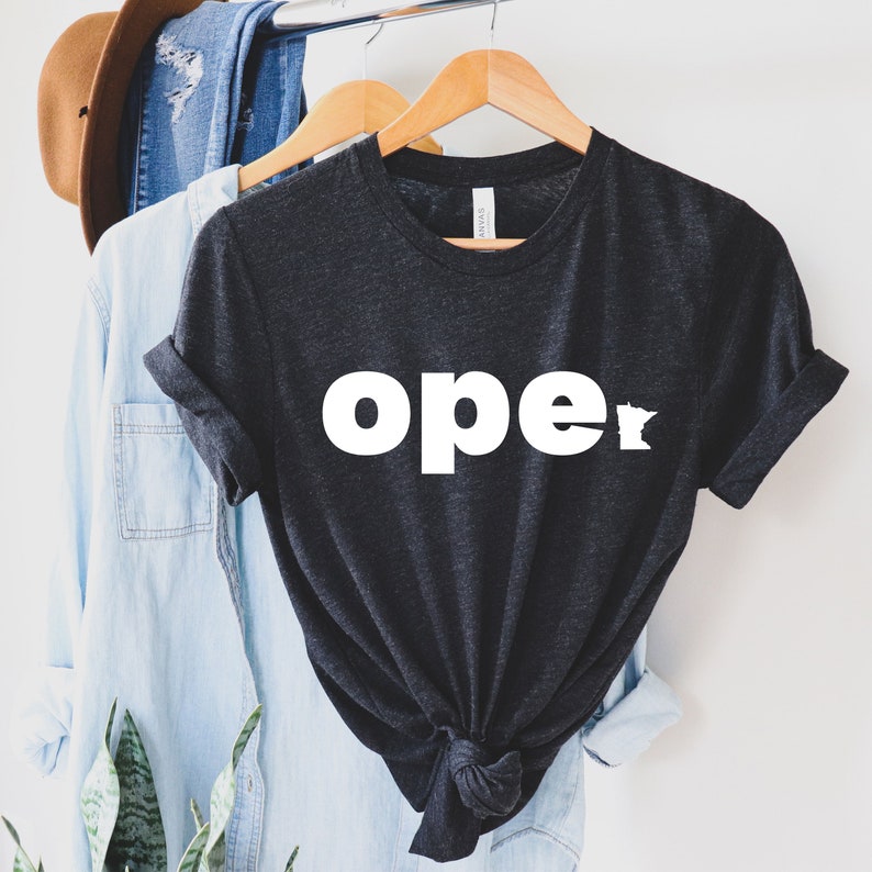 Op de afbeelding: Een donkergrijs T-shirt met het woord "ope" en een omtrek van de staat Minnesota in wit.