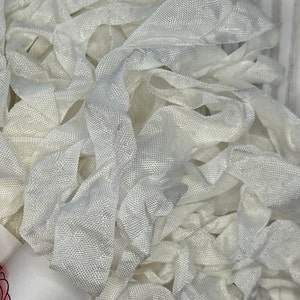 May include: A pile of white satin ribbon, perfect for crafting and decorating.