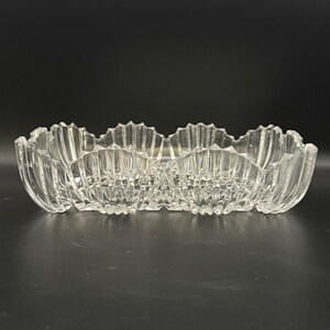 May include: A clear glass rectangular dish featuring a scalloped, shell-like edge design. The glass has vertical ribbed detailing along the sides and a transparent finish, creating a textured appearance with a repeating wave pattern along the rim.