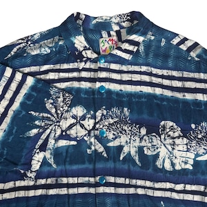 May include: A short-sleeved button-down shirt in shades of blue and white, featuring a horizontal striped pattern and a floral print. The shirt has a collar, a front button placket with bright blue buttons, and a Jams World brand label.