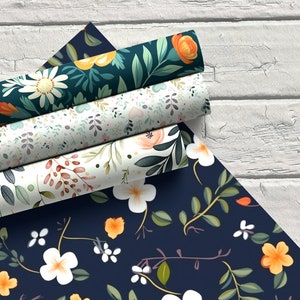 May include: Four rolls of floral patterned wrapping paper. The paper features a variety of floral designs in shades of orange, white, green, and blue. The rolls are stacked on top of each other, with the top roll partially unrolled.