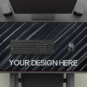 以下が含まれることがあります： 白黒のストライプのデスクマットで、白い文字で「YOUR DESIGN HERE」と書かれています。黒いキーボードと黒いマウスがマットの上に置かれています。