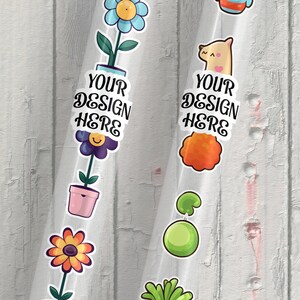 May include: Two clear plastic sheets with colorful stickers on a white wood background. The stickers feature a flower, a pot, a smiley face, a cat, a cloud, a mushroom, and the text "YOUR DESIGN HERE".