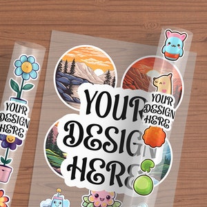 May include: A sheet of clear sticker paper with various designs. The stickers include a mountain scene, a llama, a flower, a cartoon character, and a green orb. The text "YOUR DESIGN HERE" is printed on the sticker paper.