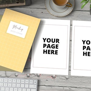 May include: A yellow book cover mockup with the text "Mockup Book Cover" on a white background. Two blank white pages with the text "Your Page Here" are on a white wooden surface with a keyboard, a cup of coffee, and a potted plant.