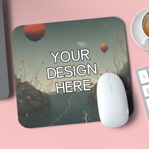 May include: A mouse pad with a surreal landscape design featuring red balloons, a body of water, and rocky outcroppings. The text "YOUR DESIGN HERE" is printed in white on the mouse pad.