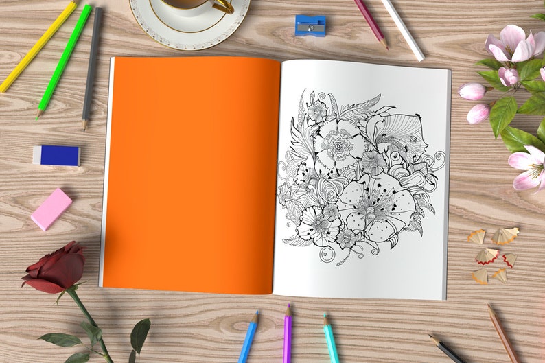 May include: An open coloring book with an intricate black and white floral design on one page. The other page is blank and orange. The book is surrounded by pencils, erasers, and a rose.