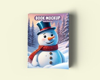 Könnte beinhalten: Ein Buch-Mockup mit einem Schneemann mit einem blauen Zylinder und einem roten Schal in einer verschneiten Winterlandschaft. Das Buchcover zeigt den Text "Book Mockup" und "Eamis Mockups".