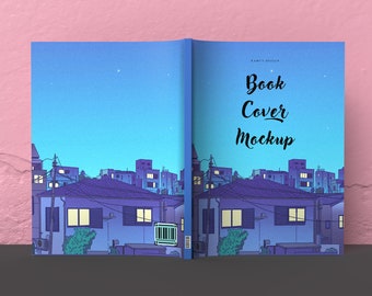 Könnte beinhalten: Ein Buchcover-Mockup mit einer Illustration einer nächtlichen Stadtlandschaft. Das Cover ist blau mit einem hellblauen Himmel und Sternen. Der Text "Book Cover Mockup" ist in schwarzer Kursivschrift geschrieben.