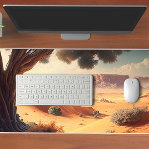 May include: A white keyboard and mouse are on a desert-themed mousepad. The mousepad features a large tree with brown branches and a desert landscape with sand dunes and mountains in the background.