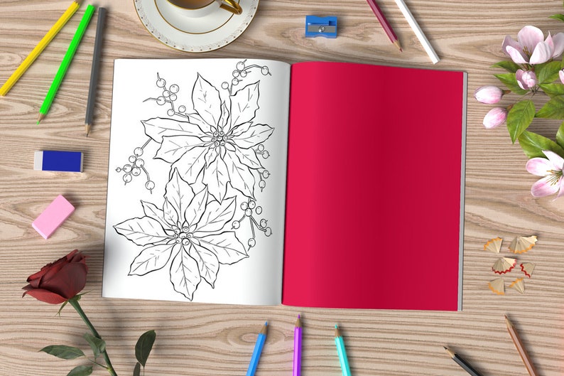 May include: An open coloring book with a black and white illustration of poinsettia flowers. The book is on a wooden table with pencils, erasers, and a cup of coffee.