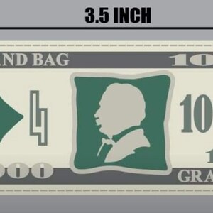 May include: A fake money bill with a green border and the text "GRAND BAG" and "1000" printed on it. The bill is 3.5 inches wide and 1.5 inches tall.
