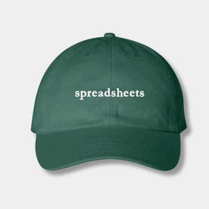 May include: A dark green baseball cap with the word "spreadsheets" in white block letters across the front. The cap has a curved brim and a rounded crown. This hat is a great gift for anyone who loves spreadsheets.