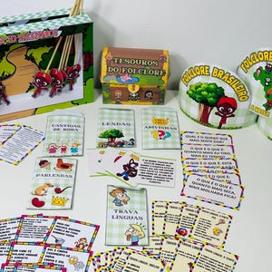 Puede incluir: Un conjunto de suministros para fiestas con temática de folclore brasileño, que incluye un cofre del tesoro, tarjetas ilustradas y adornos decorativos. Los artículos presentan personajes de dibujos animados y las palabras "Folclore Brasileiro".