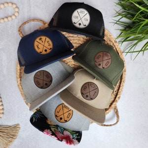 May include: Six different baseball caps with a variety of colors and designs. Each cap features a leather patch with a golf-themed design. The patches include the words "Just Fore Fun", "Kiss", "Bird", "Good Fore", "R.T." and "B.W."