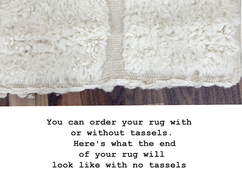 May include: Close-up of a cream-colored rug with a shaggy texture and a woven border. The rug's edge is visible, showing a detailed fringe. The text on the image says, "You can order your rug with or without tassels. Here's what the end of your rug will look like with no tassels."
