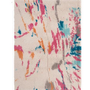 May include: A rectangular rug with a cream-colored background and a colorful abstract design. The design features splashes of pink, orange, teal, and gray. The rug has a fringed edge and is made of a soft, textured material.