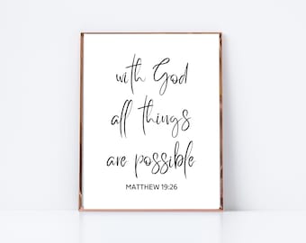 Op de afbeelding: Een wit ingelijst print met zwarte kalligrafie met de tekst "met God is alles mogelijk" en "MATTHÉÜS 19:26".
