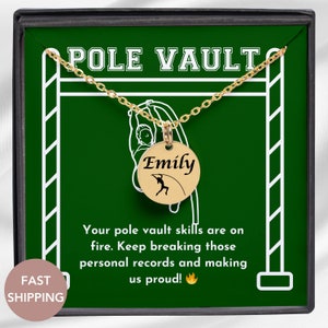 May include: A gold necklace with a round pendant featuring a pole vaulter silhouette and the name "Emily". The necklace is displayed in a green box with a white pole vault bar and the text "POLE VAULT". The box also includes the text "Your pole vault skills are on fire. Keep breaking those personal records and making us proud!"