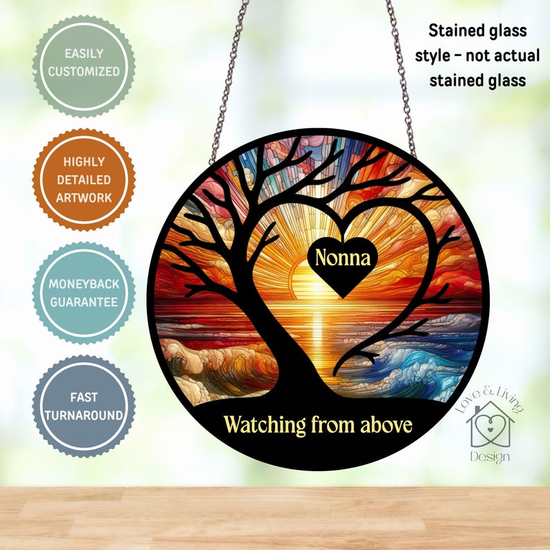 May include: A round, stained glass style wall hanging with a tree silhouette forming a heart shape. The heart frames a sunset scene with the word "Nonna" inside. Text includes "Watching from above" and "Love & Living Design".