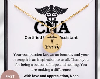 May include: Gold necklace with a pendant that says "CNA Certified Nursing Assistant" and has a medical symbol with the name "Emily" engraved on it. The necklace is in a black gift box with a white card that says "Your compassion knows no bounds, and your strength is an inspiration to us all. Thank you for being a beacon of hope and healing. You are making a difference. With love and appreciation, Noah."