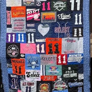 May include: A colorful quilt made from repurposed t-shirts featuring various sports team logos, names, and numbers. The quilt includes the words "Select", "Ramirez", "Wichita Panthers", "State Championship", "Fire", and "State Bound".