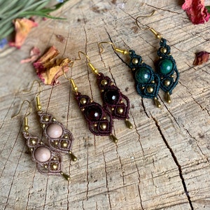 Op de afbeelding: Drie paar handgemaakte oorbellen met edelsteen kralen en gouden accenten. De oorbellen zijn gemaakt met bruine, groene en roze kralen. De oorbellen hangen aan gouden haakjes.